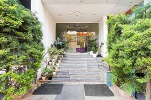 A staircase leading to a building entrance with potted plants on either side. - FabHotel Prime IJ Suites - Kasavanahalli (Bangalore)