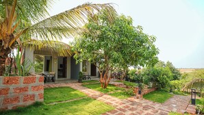 A house with a patio, a small garden, and a view of the countryside. - Fabhotel Nakshtra Resort (Tasgaon)