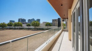 A balcony with a city view, a wooden ceiling, and a glass railing. - FabHotel 24x Living (Gurugram)