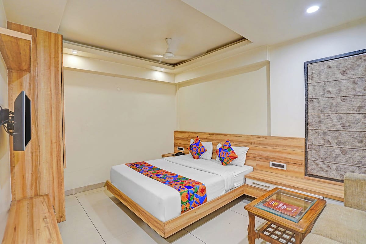 Une chambre à coucher avec un lit, une table de chevet et un téléviseur fixé au mur.