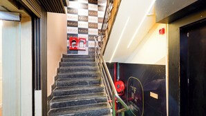 Una escala amb baranes metàl·liques, una paret amb un dibuix repetit que diu 'HAVANA', i una porta a la base.
