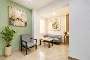 A modern interior with a grey sofa, a wooden coffee table, and a potted plant. - Fabhotel Moro Gujranwala Town (New Delhi)
