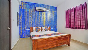 Een slaapkamer met een houten bed, een blauwe muur met structuur, een airconditioning en een paars gordijn.