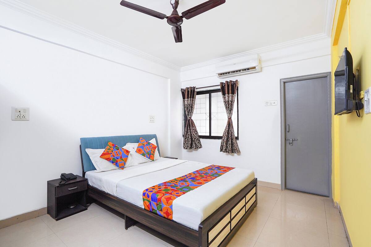 A bedroom with a bed, bedside table, and a ceiling fan.