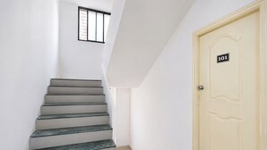 A staircase leading to a door marked with the number 101. - Fabhotel Ateethi Residency (Pune)