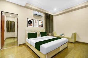 A hotel room with a bed, a mirror, a window with curtains, an air conditioning unit, and framed artwork on the wall. - FabHotel Runway - Patrika Gate (Jaipur)