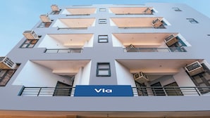 A multi-story building with balconies, a sign reading 'Via,' and air conditioning units. - Via Chahal (New Delhi)