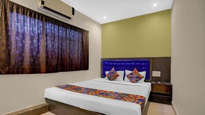 A hotel room with a bed, a nightstand, an air conditioning unit, and a window with curtains. - Via Shera Residency (Mumbai)