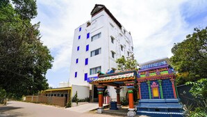 Un edificio con una entrada tradicional y colorida, junto a una estructura moderna de color blanco con ventanas azules.