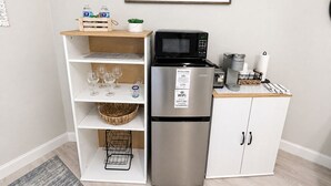 Une petite cuisine équipée d’un réfrigérateur, d’un four à micro-ondes et d’une machine à café.