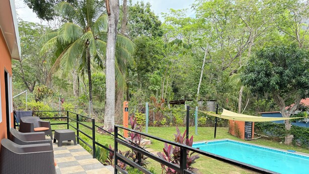 Uma área à beira da piscina com piso xadrez, mobiliário de exterior e uma piscina.