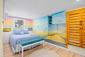 A bedroom with a bed, bench, and a mural of a landscape with birds. - Updated 6BR | 2.5 Blocks to Beach | Sleeps 13 (Ventnor City)