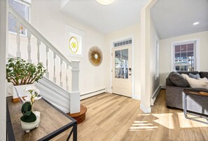 A spacious living area with a staircase, a sofa, and a dining table. - Modern 6BR | Sleeps 14 | 1.5 Blks to Beach (Ventnor City)