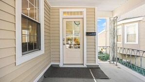 Una casa con una porta d'ingresso, una finestra, una cassetta delle lettere e un piccolo portico.