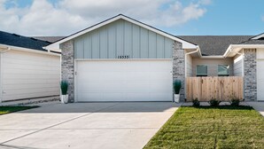 Une maison de plain-pied avec un garage, le numéro « 15333 » inscrit sur la porte du garage, et une clôture en bois.