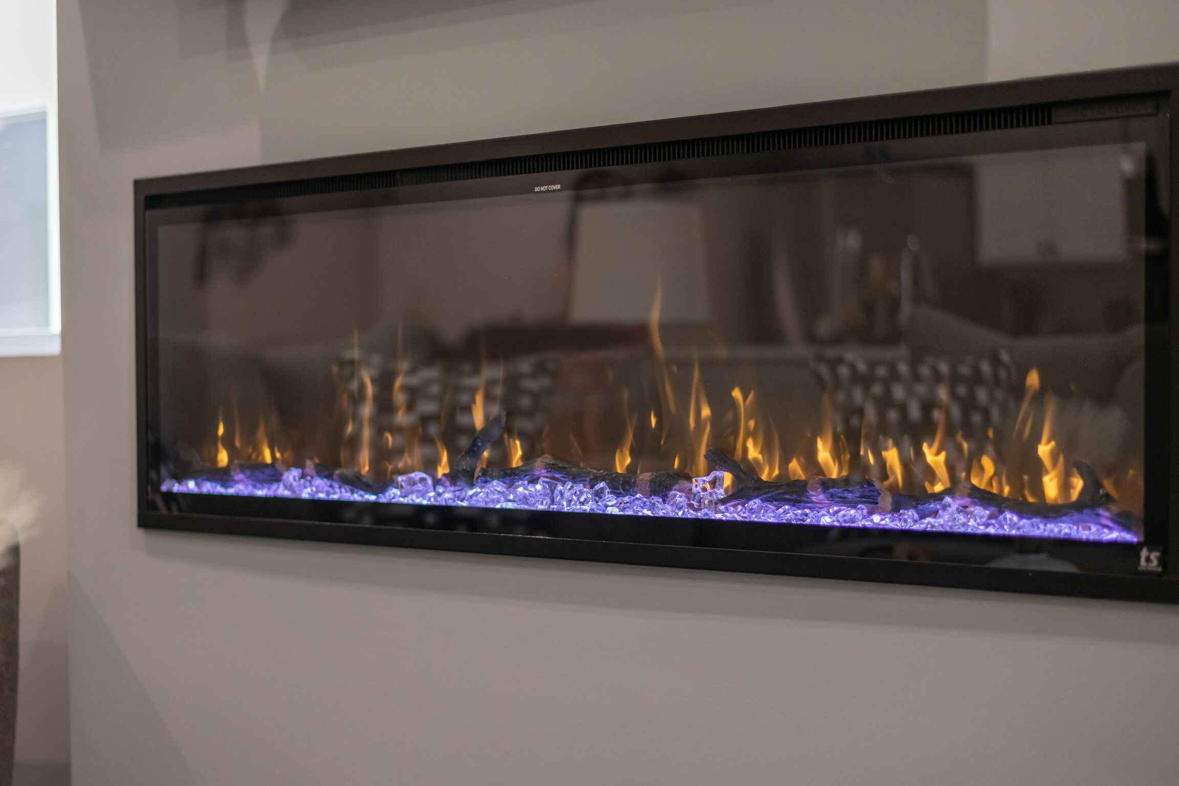 Chimenea empotrada en la pared con fuego a la vista.