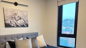 A bedroom with a bed, pillows, a blanket, a painting, and a window with a view. - TopNotch 4-bedroom 4 bathroom (Birmingham)