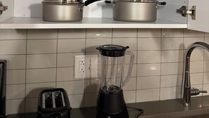 A kitchen with white cabinets, stainless steel pots, a blender, and a toaster. - TopNotch 4-bedroom 4 bathroom (Birmingham)