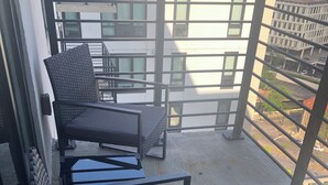 A balcony with a seating area consisting of a sofa and two chairs, a metal railing, and a view of buildings and a street. - TopNotch 4-bedroom 4 bathroom (Birmingham)