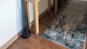 A hallway with a wooden console table, a vase, a rug, and a large abstract painting on the wall. - TopNotch 4-bedroom 4 bathroom (Birmingham)