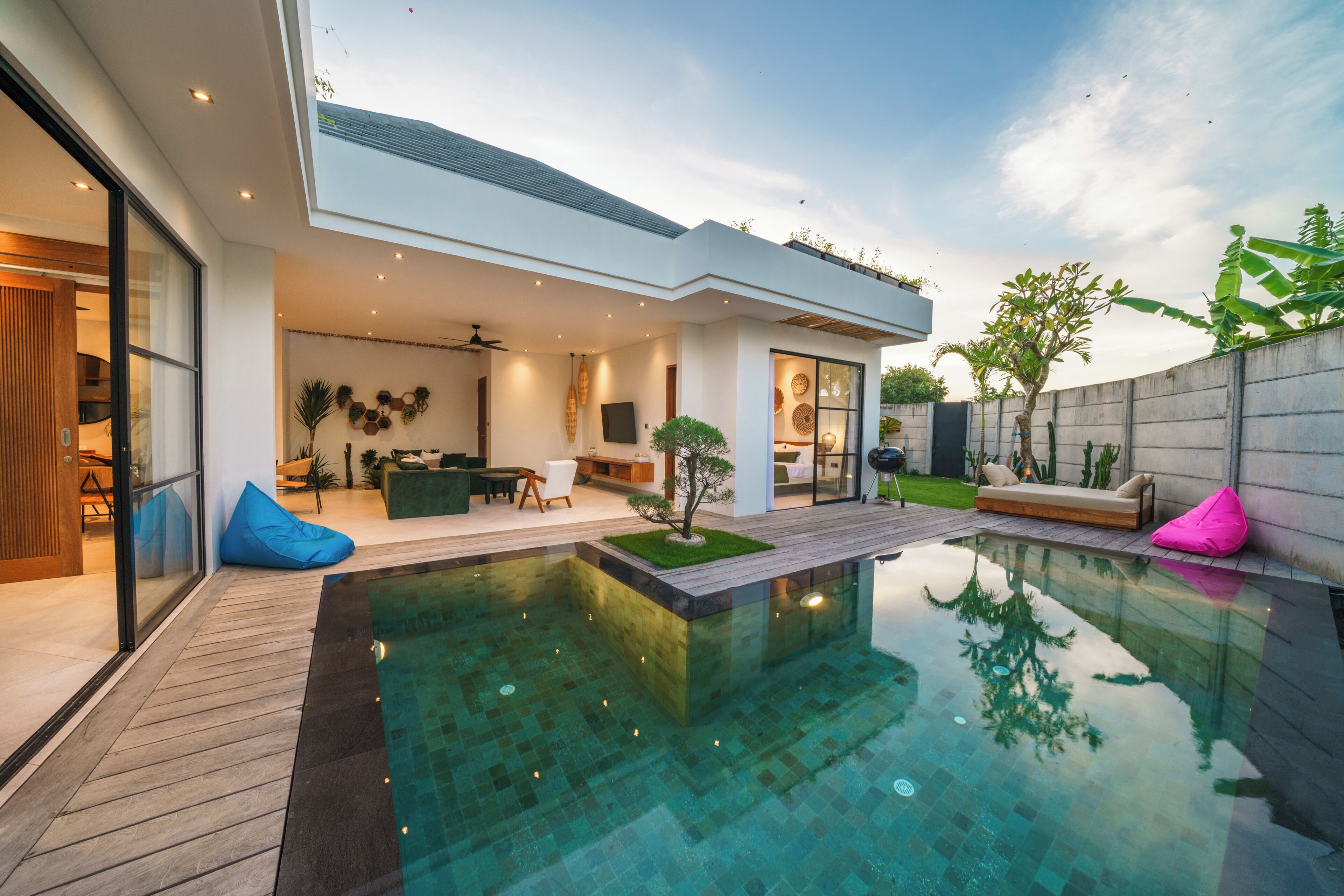Ein modernes Haus mit Schwimmbad, Terrasse und Blick zum Himmel.