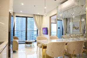 A modern dining area with a marble table, gold chairs, and pendant lighting. - 2BR 2BA Family Apt | Plaza View Balcony | Central | Near Mall & Park (Ho Chi Minh City)
