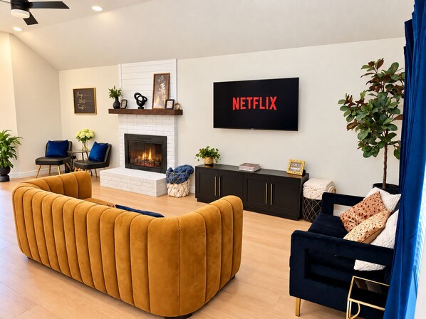 A modern living room with a fireplace, a sofa, a TV, and decorative items.