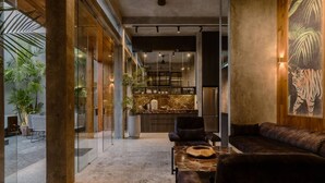 Un interior moderno con sofá, una mesa y una zona de cocina con encimera de mármol.