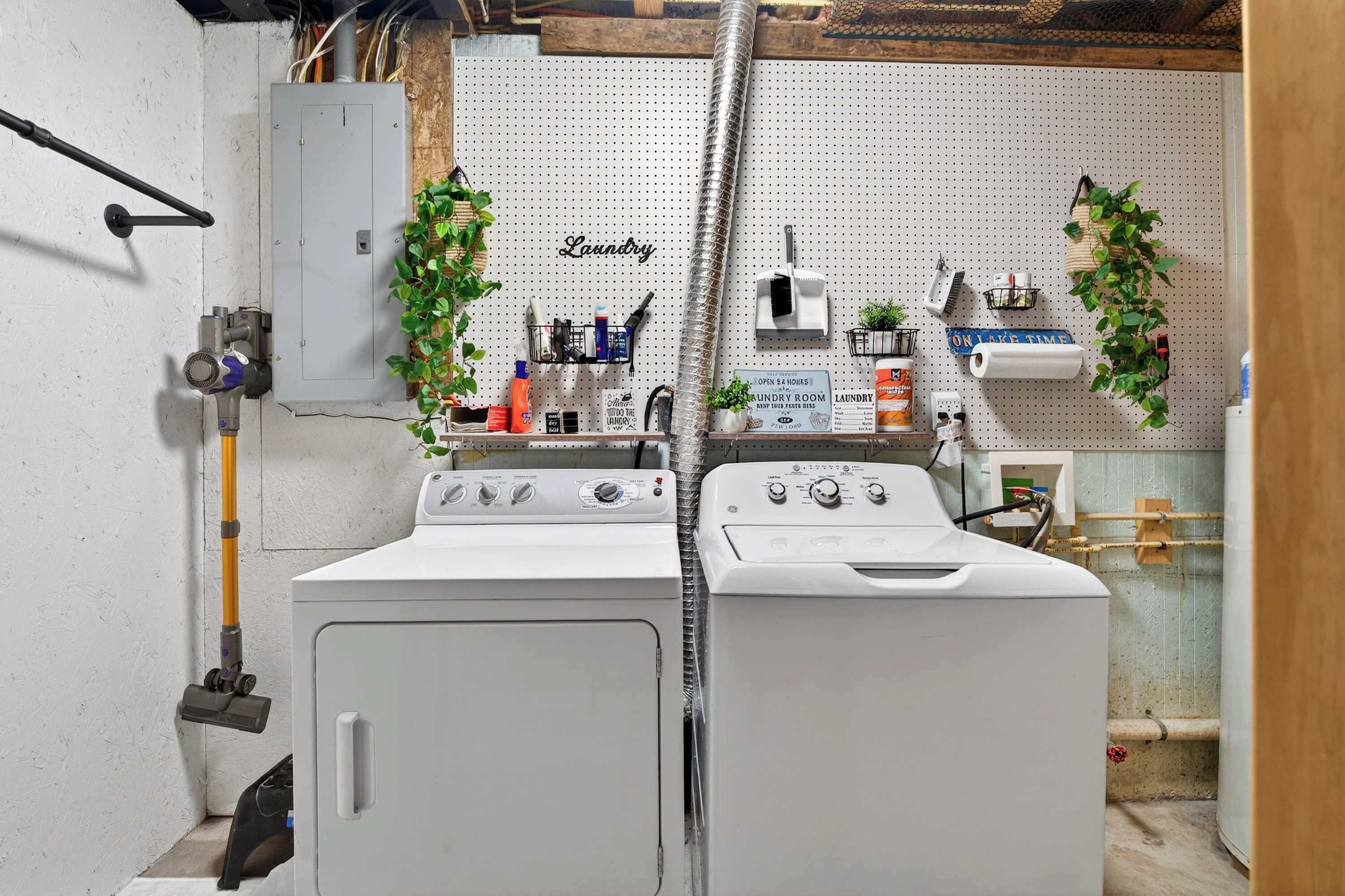 A laundry room with two washing machines, a utility room sign, and a pegboard with various items.