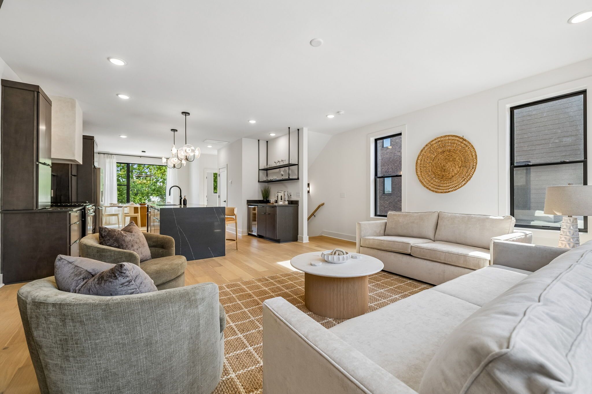 A modern living room with a sofa, armchairs, and a coffee table.