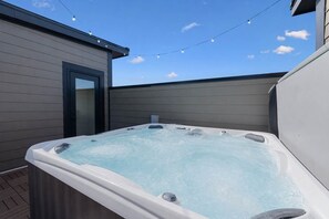 A hot tub with a clear view of the sky and a door to the left. - Iconic retreat w/ exclusive rooftop lounge & spa! (Nashville)