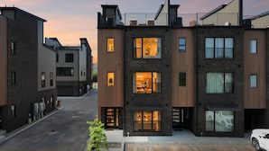 A modern multi-story residential building with visible balconies, large windows, and a driveway. - Iconic retreat w/ exclusive rooftop lounge & spa! (Nashville)