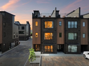 Un immeuble résidentiel moderne à plusieurs étages, doté de balcons apparents, de grandes fenêtres et d’une allée.