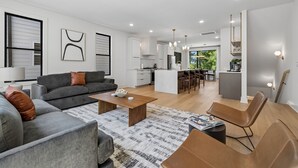 Ein modernes Wohnzimmer mit einem grauen Sofa, einem Couchtisch und einem braunen Ledersessel.