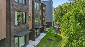 Ein modernes Mehrfamilienhaus mit großen Fenstern und Balkonen.