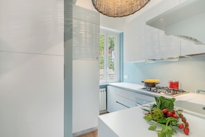 A modern kitchen with white cabinets, a gas stove, and a window overlooking greenery. - Kenyon Charm - Total Sea View, Alassio, Italy (Alassio)