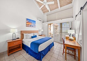 Ein Hotelzimmer mit Bett, Nachttischen, einem Schreibtisch und Blick ins Freie.