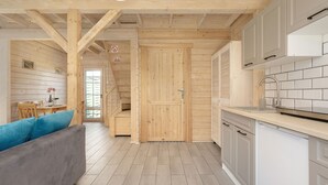 Una cocina moderna con armarios blancos, un lavamanos de acero inoxidable y piso de madera.
