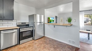 A modern kitchen with stainless steel appliances, a dishwasher, and a built-in oven. - Bright Beautiful 2BR Near Broadmoor with King Bed, Jetted Tub, Yard & Deck (Colorado Springs)