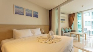 Een hotelkamer met een groot bed, een bank, een kleine tafel en uitzicht.