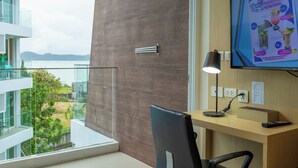 Een moderne kamer met een bureau, stoel en een televisie waarop een promotievideo wordt afgespeeld.