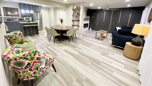 A modern living space with a dining area, kitchen, and seating area. - The Garland Getaway • Backyard Oasis • Family Friendly • Near Dallas (Garland)