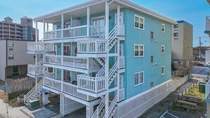 A multi-story building with balconies, a stairway, and a visible ground floor entrance. - Sinbad – Newly Renovated • Steps to the Beach • Midtown OC 2BR 1.5 BA (Ocean City)
