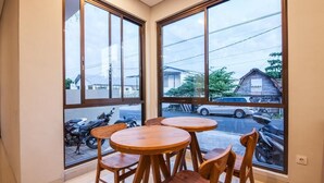 A room with large windows, wooden tables, and chairs. - Eclipse Kerobokan (Seminyak)