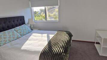 Tabla de planchar con plancha y ropa de cama