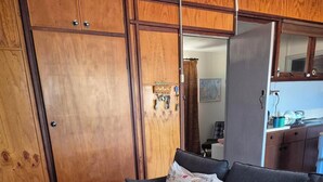 Un salon avec un canapé, une table basse en verre, un tapis à motifs et des meubles en bois.