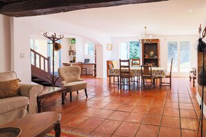 A spacious living area with a fireplace, a dining table, and a staircase leading to another room. - Le Vieux Moulin Cotignac – Perfect Base to Explore Provence. (Cotignac)