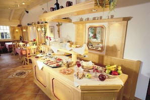 A breakfast buffet with various food items and a mirror reflecting the room. - Apartment type A 11, shower and WC, balcony, kitchenette, TV, WLAN (Ruhpolding)