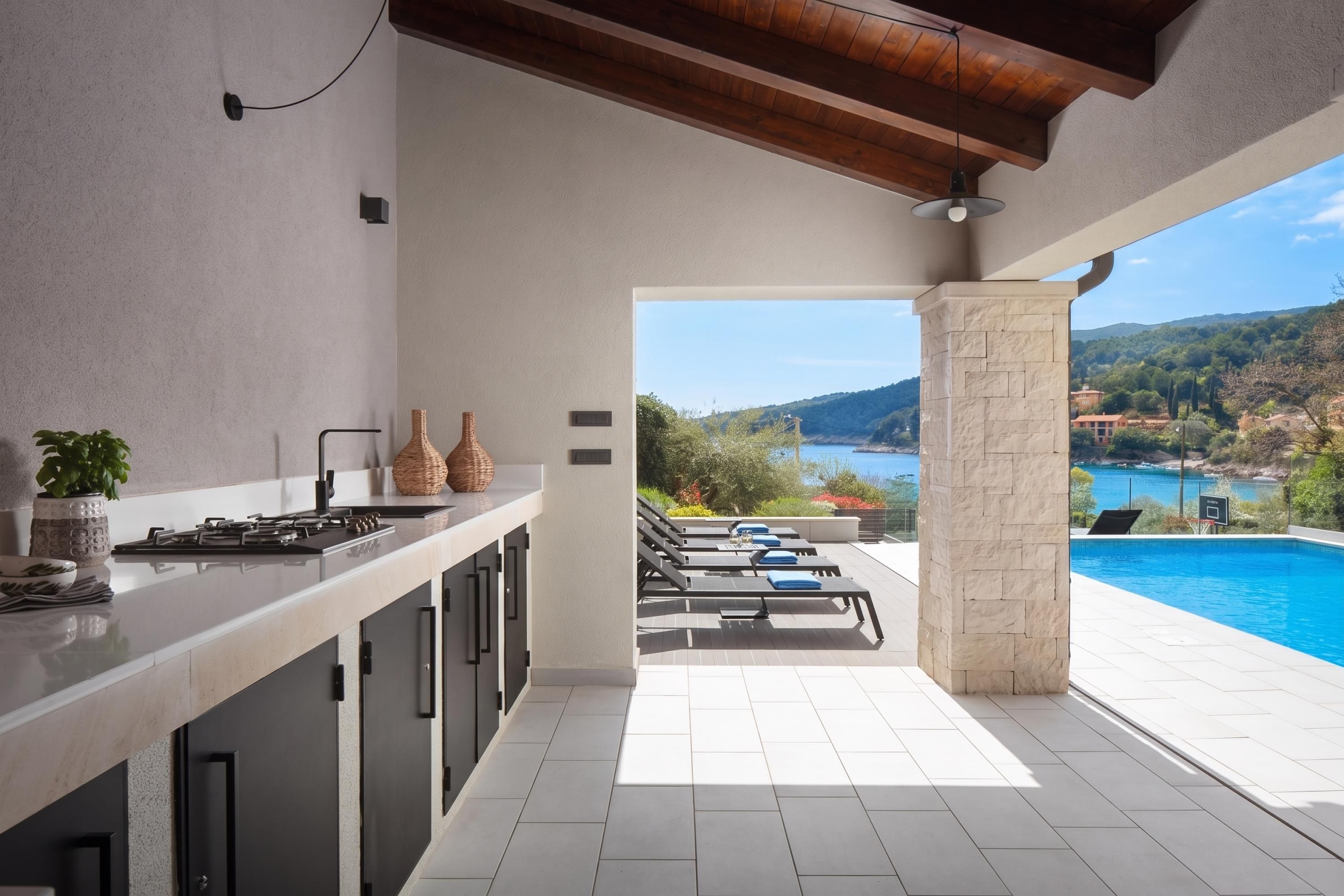 Una cocina moderna con vistas a una piscina y un paisaje panorámico.