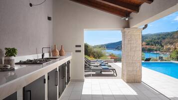 Una cocina moderna con vistas a una piscina y un paisaje panorámico.